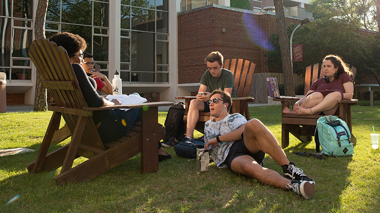Students sitting and chatting on lawn