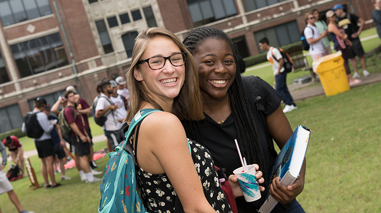Two students hugging at orientation event