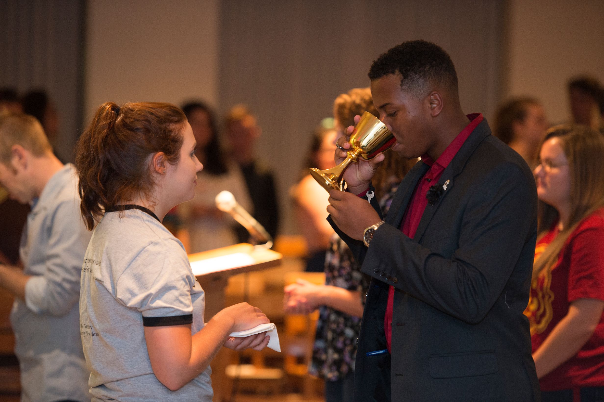 Student sipping from cup during Mass