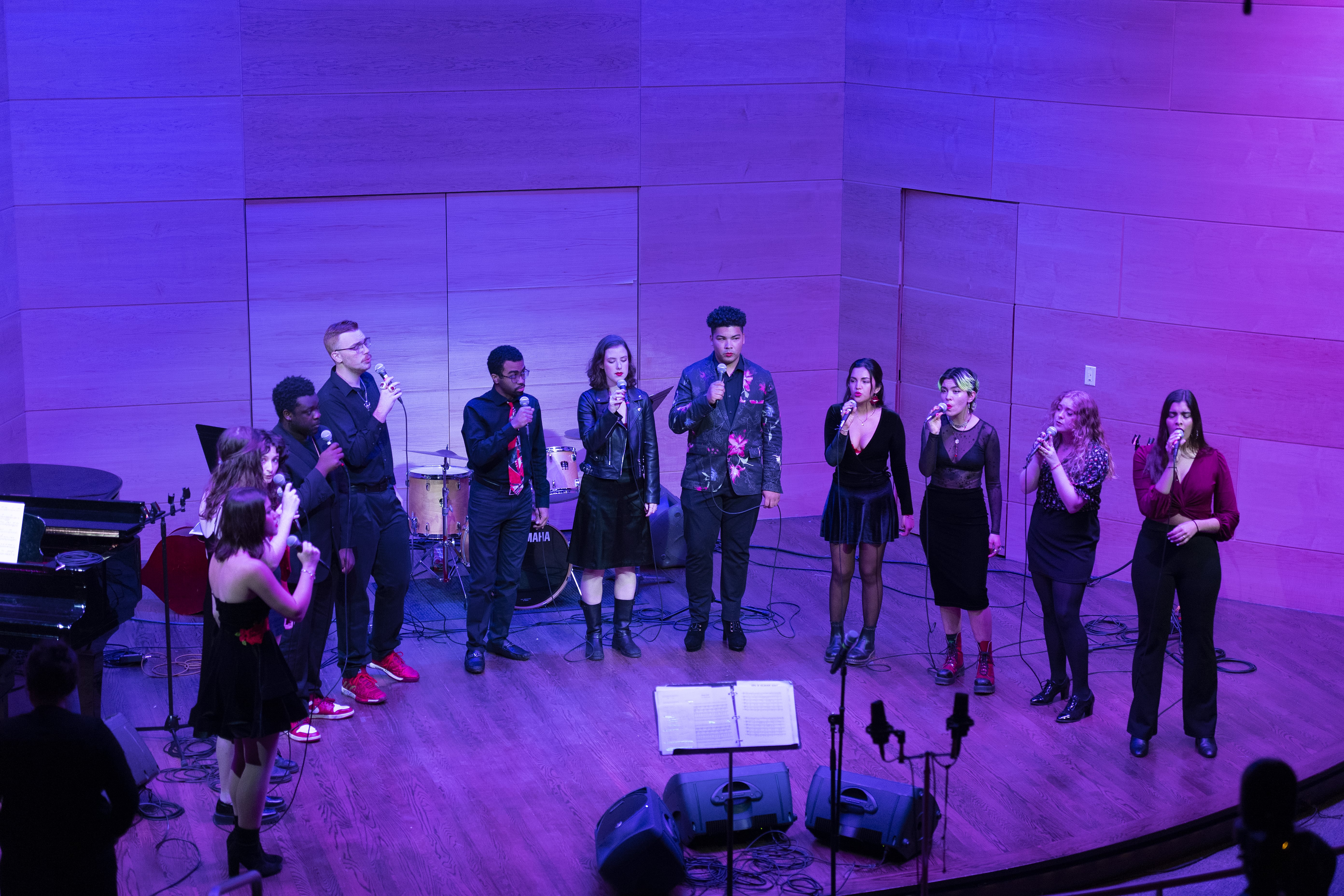 Crescent Collective Vocal Ensemble in purple lighting, singing.