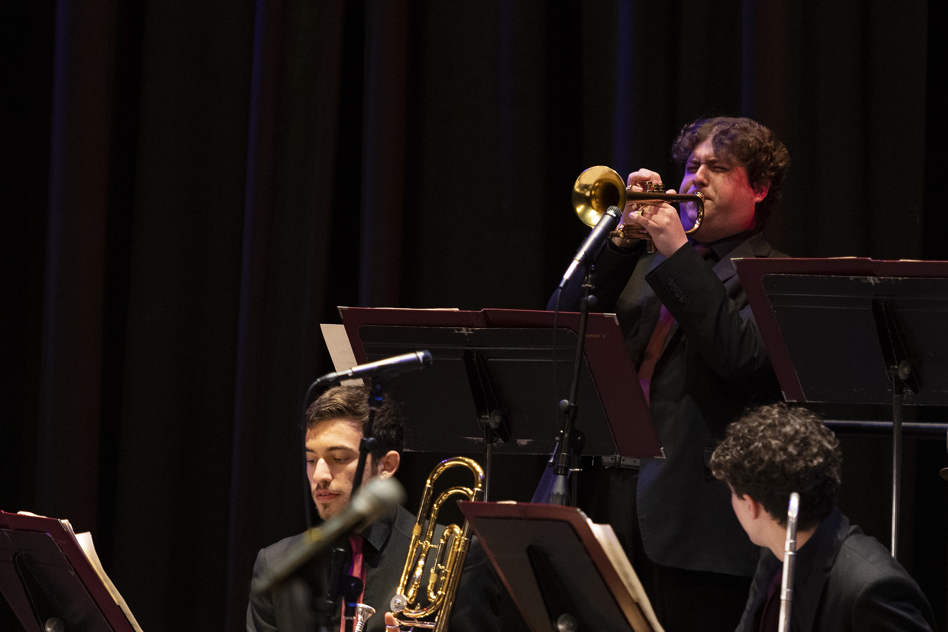 A trumpet player in Loyola's Jazz Ensemble plays a high note with intensity.