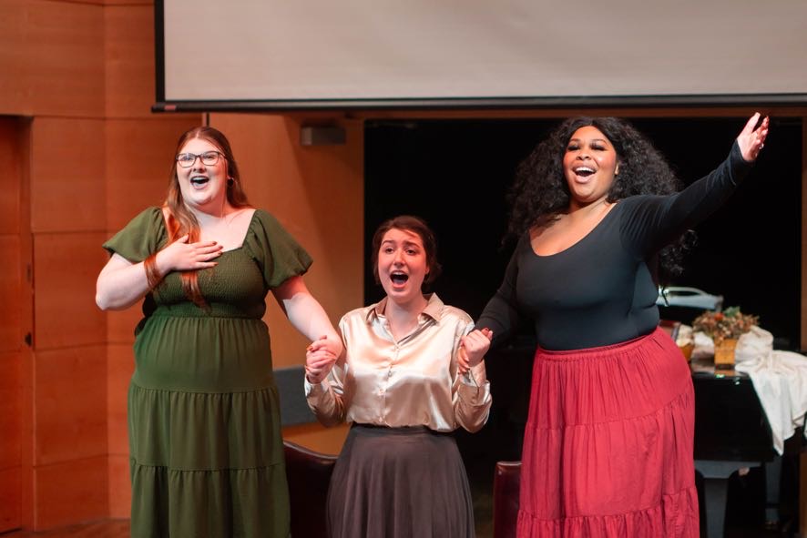 Three opera singers singing in an opera scene.