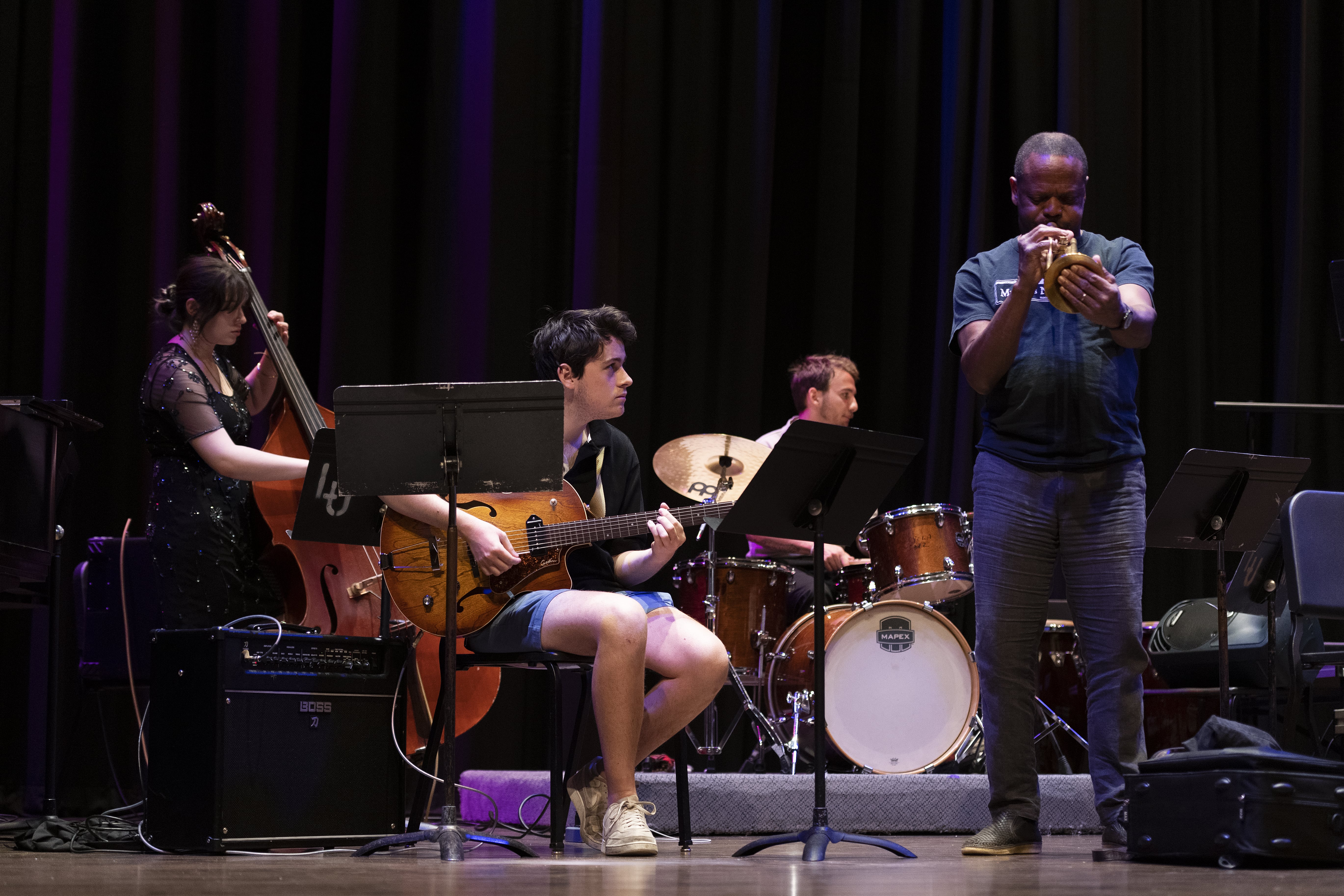 A photo of the rhythm section of a Loyola Jazz band performing alongside a guest trumpet player.