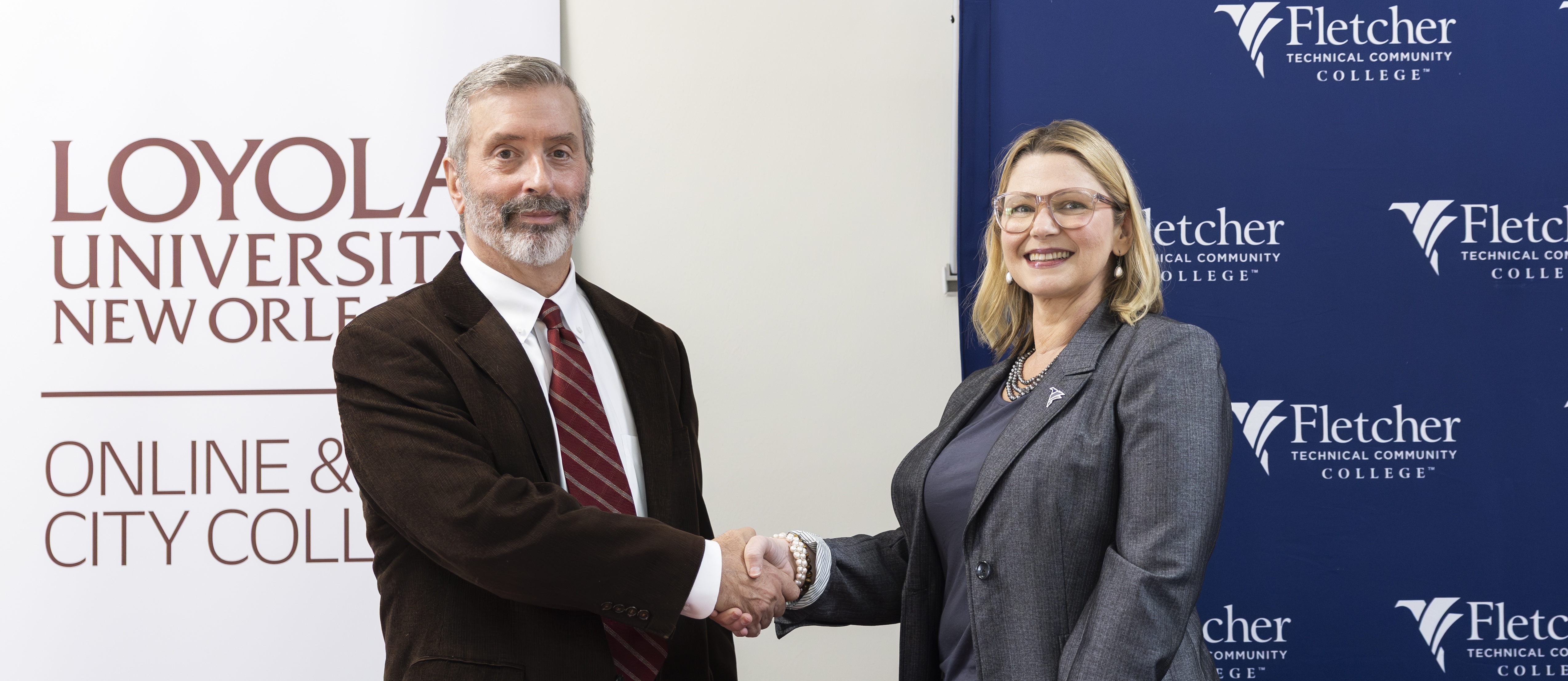 Dr. Paul Cesarini of Loyola University New Orleans and Dr. Carrie Cortez of Fletcher Technical Community College shake hands after signing a transfer partnership agreement between the two institutions.