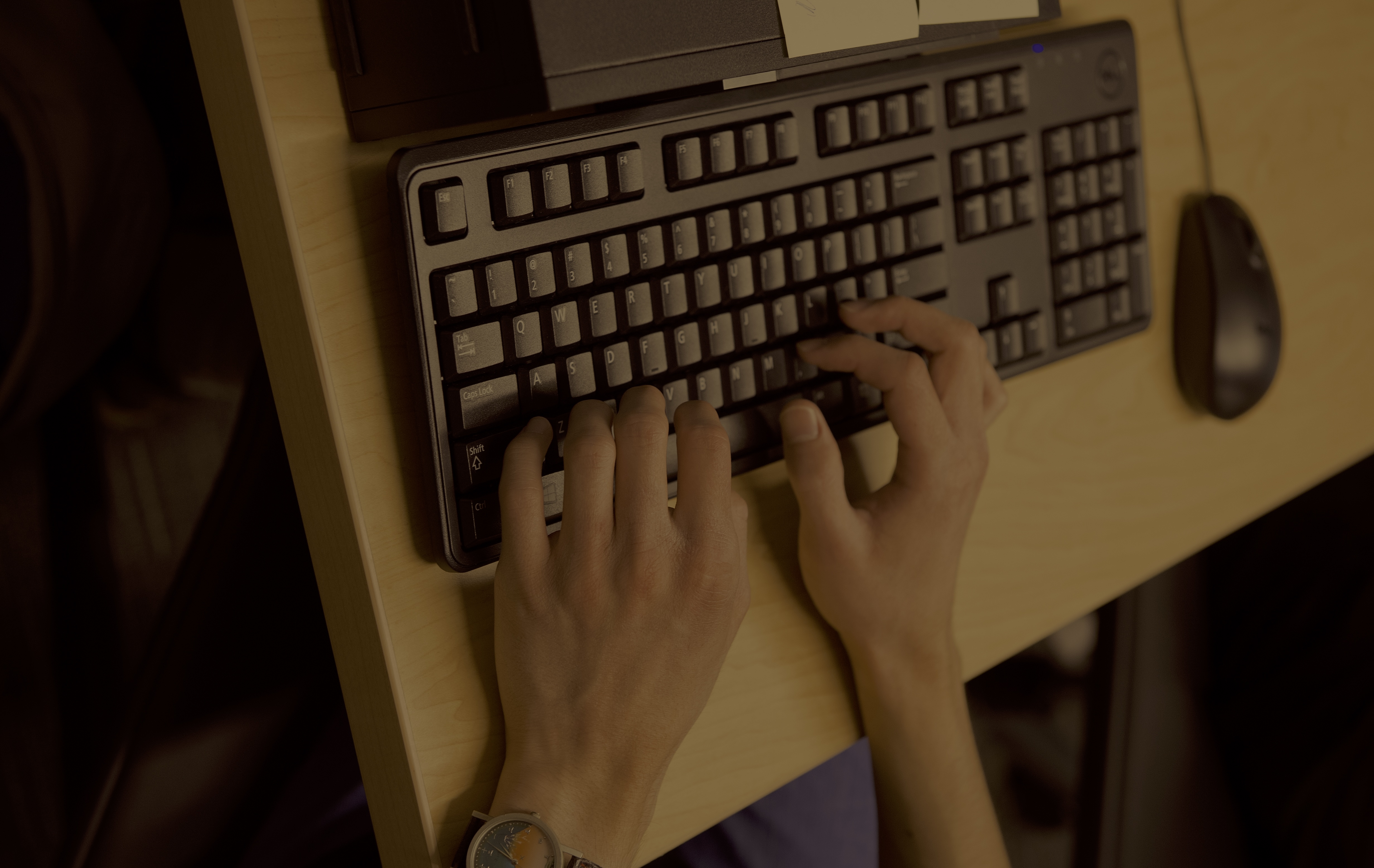 A student's hands typing on a keyboard